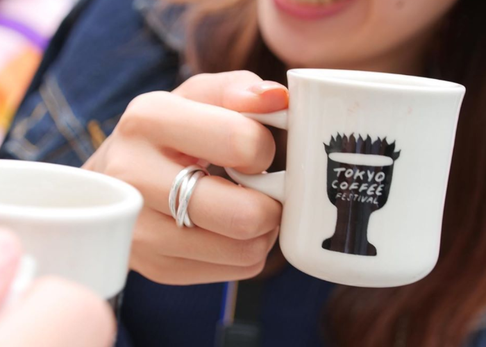 Lady holding a Tokyo Coffee Festival mug