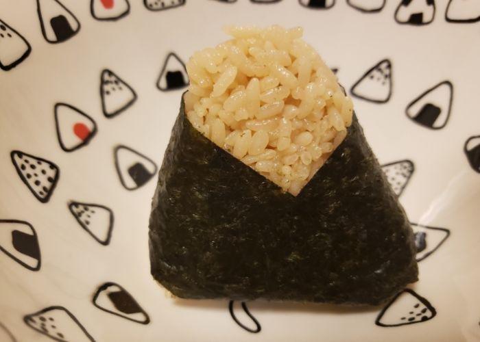 Tuna mayo onigiri on a backdrop of small onigiri rice ball illustrations