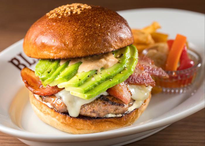 Juicy burger patty sandwiched between two burger buns, with avocado, from Blacows Burger in Ebisu, one of the best burgers shops in Tokyo