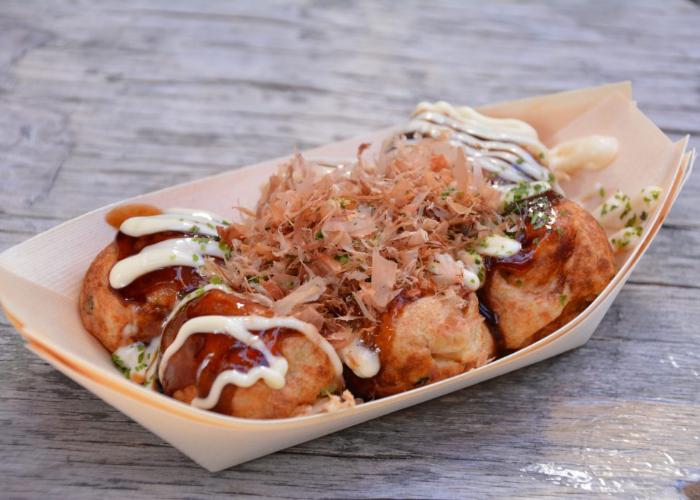 Takoyaki octopus balls covered in sauce, Japanese mayo, aonori, and katsuobushi fish flakes