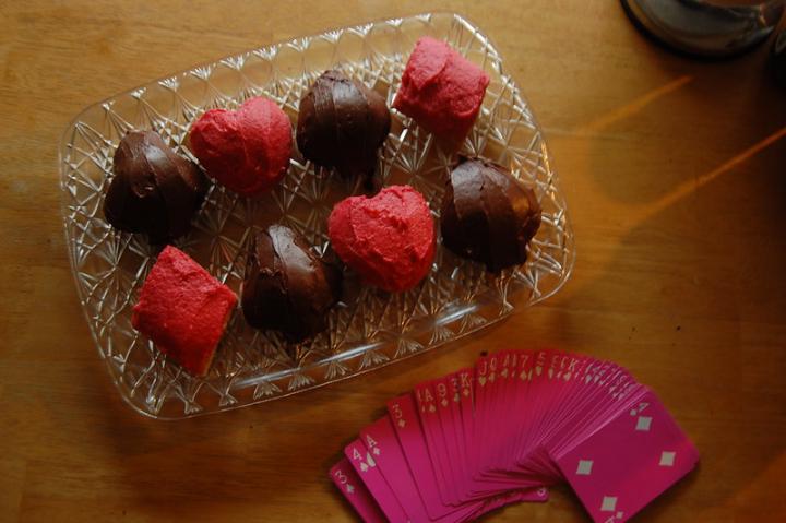 Red and black chocolates shaped like card suits next to cards