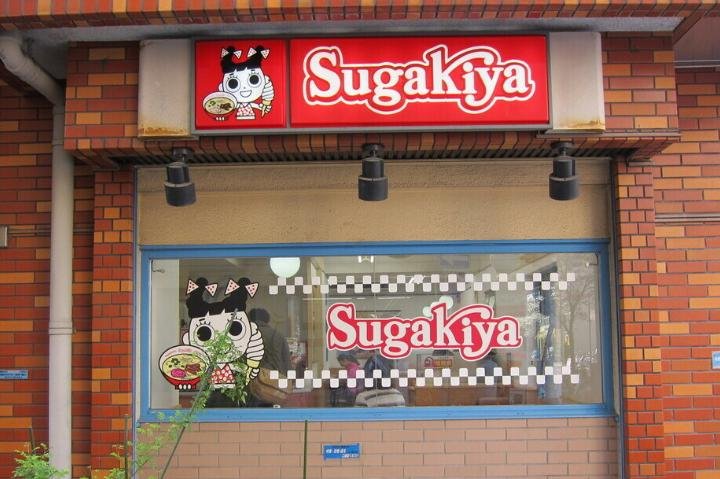 Sugakiya logo, red checkered with little girl holding ice cream and ramen