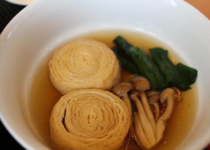 Yuba, or tofu skins, folled up in a dashi soup stock with veggies