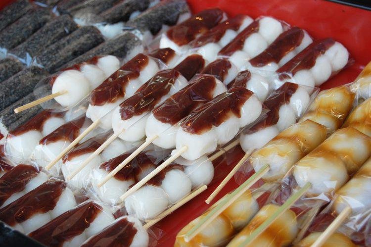 Three types of dango displayed, one coated in red bean and another coated in sauce