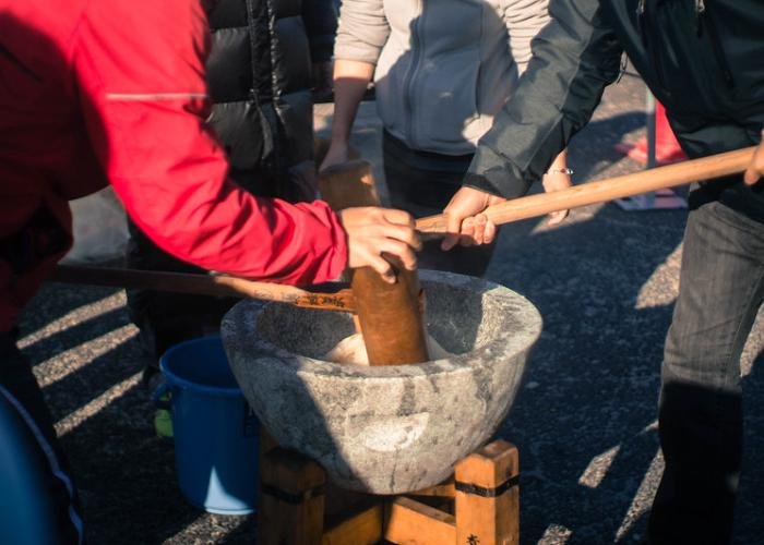 Pounding mochi with two wooden hammers