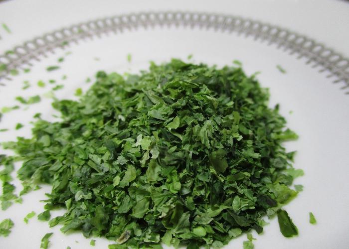 Pile of green seaweed flakes on white plate