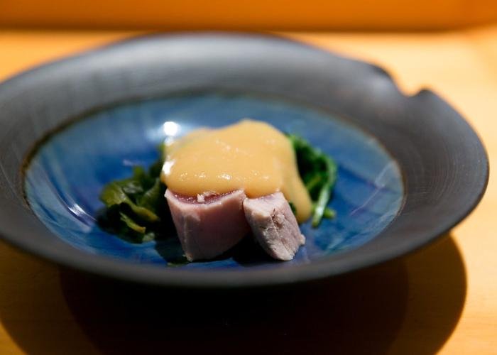 Tuna with seaweed and dollop of yellow Japanese mustard on blue plate