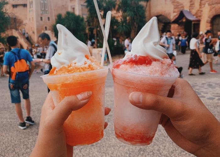 On the left side, there is an orange colored float with soft-serve ice cream on top. The right side displays a strawberry flavored float with soft serve on top.