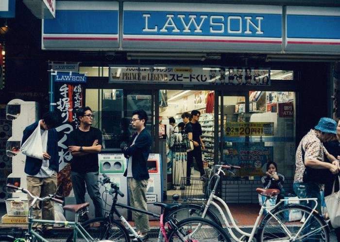 Lawson convenience store exterior with a group of three men outside