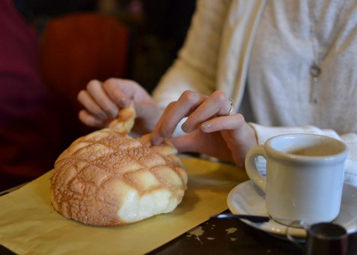 Sweet, fluffy melon pan (Japanese melon bread) being torn apart