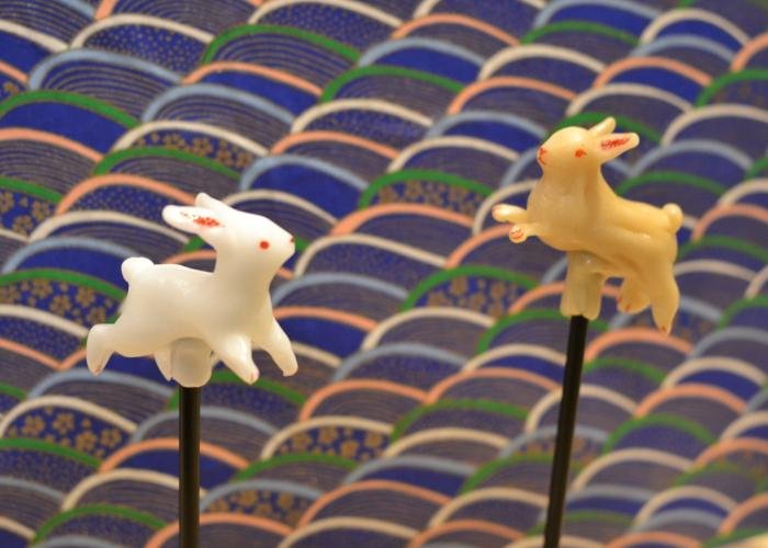 Two Amezaiku rabbits (Japanese Candy Sculpture) against a traditional Japanese-patterned backdrop