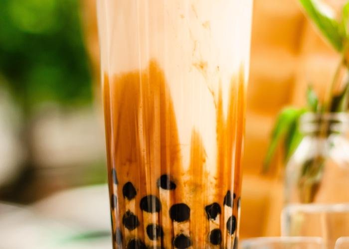 A popular Japanese drink, bubble tea (also known as tapioca pearl tea or boba tea). The black bubbles sit in a mocha-colored milky tea