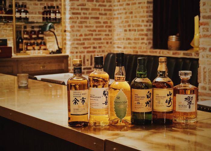 Bottles of Japanese whisky, a popular alcohol in Japan, lined up on a bar counter