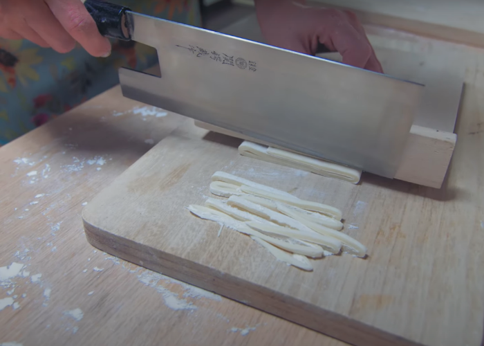 Cutting the udon noodles using a wooden guide