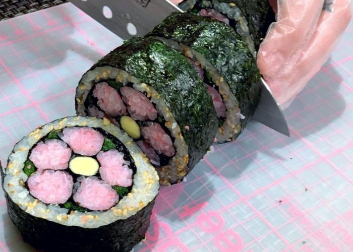 Knife cuts through sushi roll during Decorative Sushi Making Class