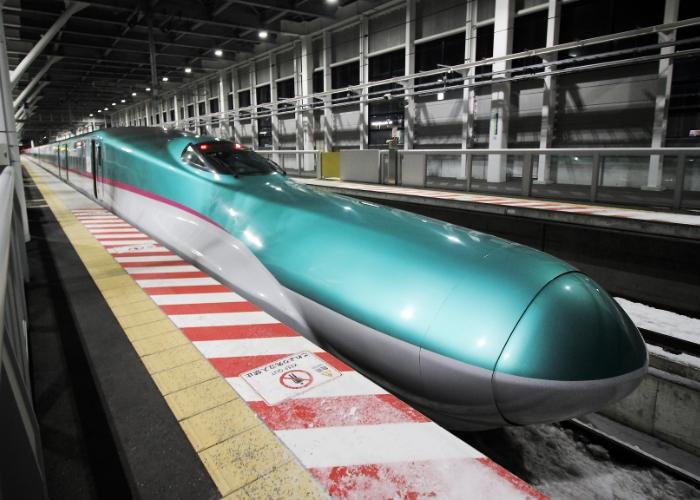 JR East Shinkansen Hayabusa green bullet train stopped at a station