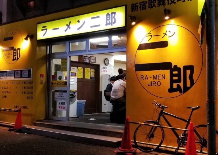 Ramen Jiro shop exterior with a glowing yellow sign that reads "Ramen Jiro" in Japanese