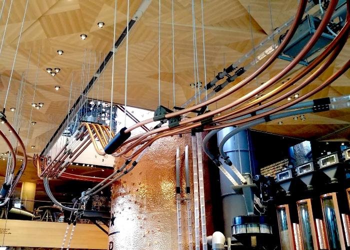 Interior of the Starbucks Reserve Roastery Tokyo, a ceiling with twisting pipes