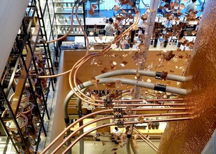 Starbucks Reserve Roastery Tokyo showing the layout of the store with several floors, twisting pipes, and metal sakura petal decor
