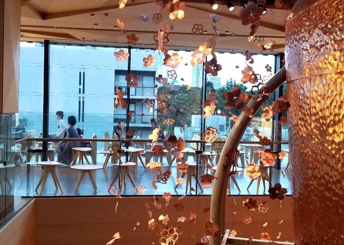 Interior of Starbucks Reserve Roastery Tokyo with metal sakura petals cascading from the ceiling