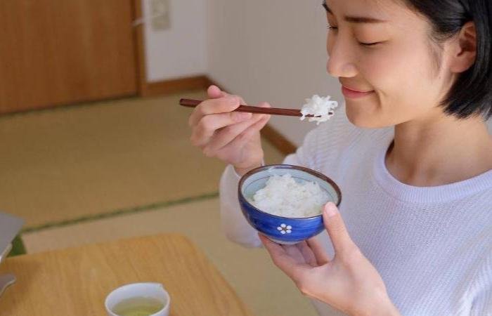 Woman wearing a white shirt eating white rice 