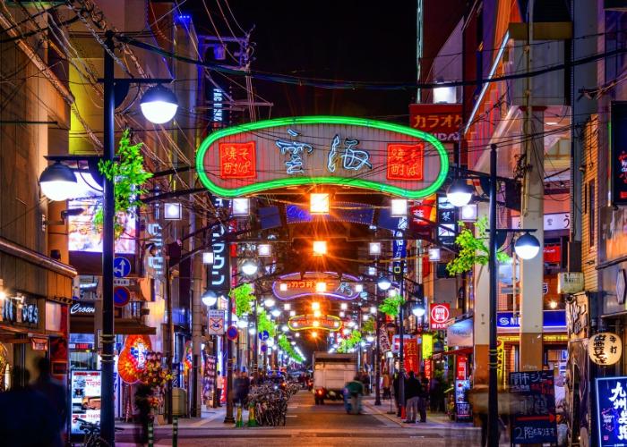 Backstreets of Hiroshima city at night, with neon signs aglow