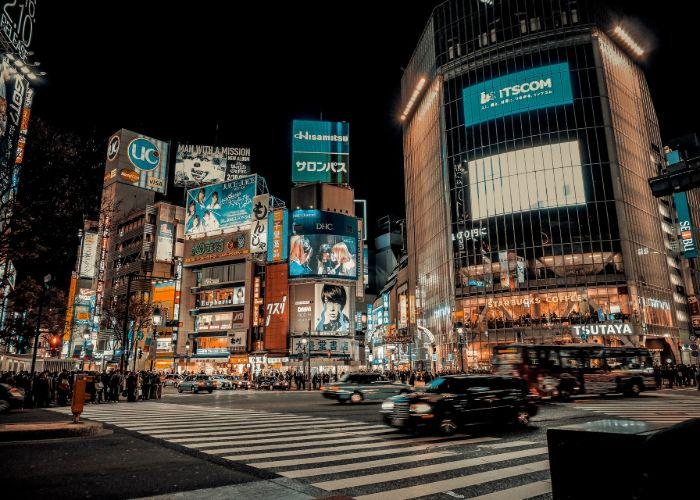 Shibuya at night - the crossing with the buildings illuminated from the inside, against a black sky