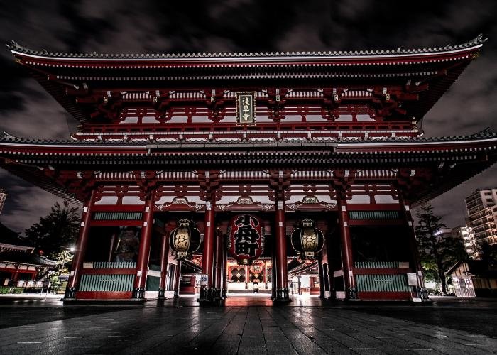 Sensoji Temple in Asakusa at night, with red lantern and dramatic architecture lit up against a black sky