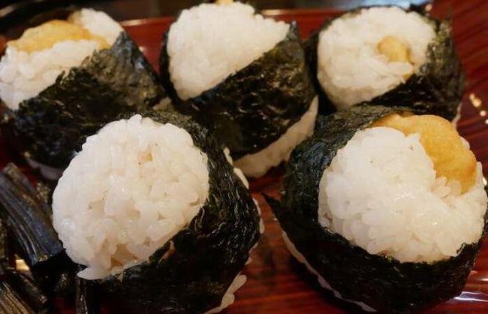 Five tenmusu rice balls with tempura shrimp inside on dish