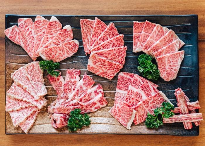 Slices of wagyu beef on a black stone tray