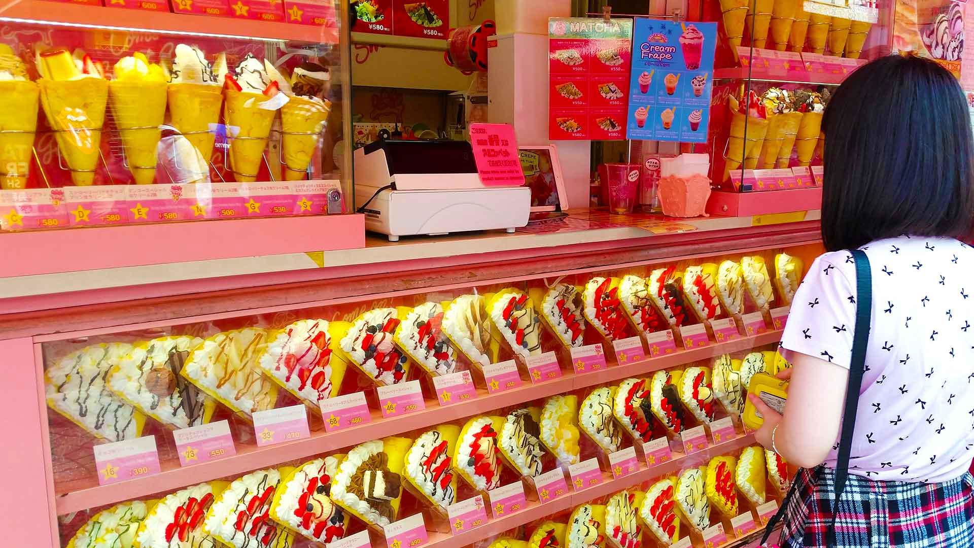 Woman chooses dessert at colorful Tokyo crepe shop