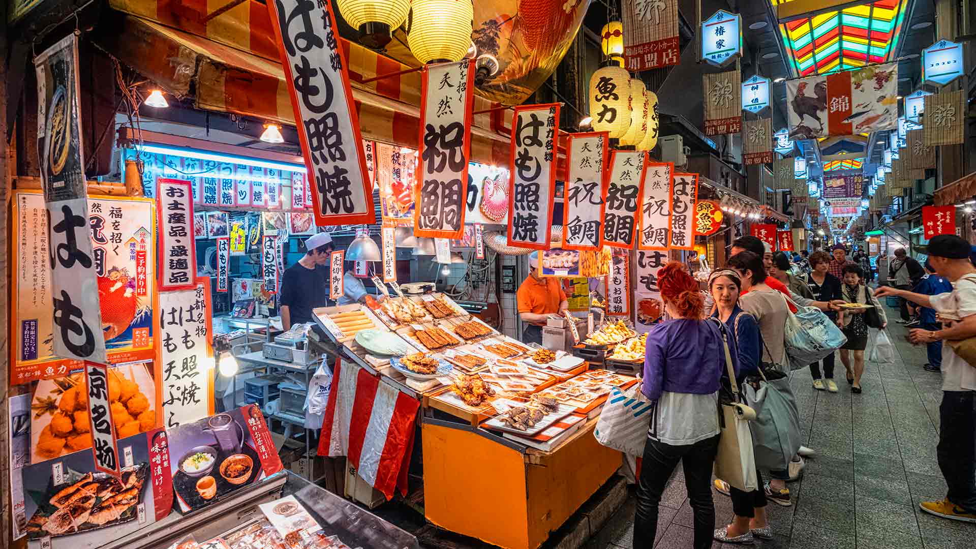 Vibrant Nishiki Market stalls with diverse Japanese street food and lanterns.