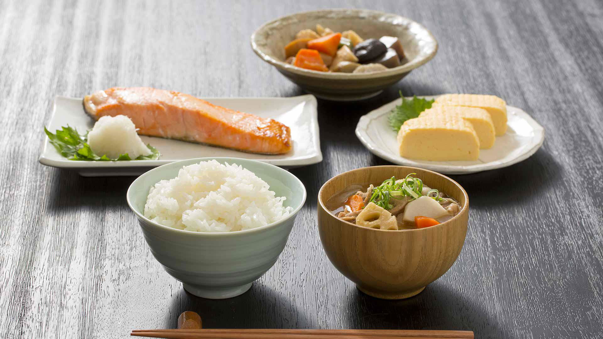 Traditional Japanese meal with salmon, rice, and side dishes on a table
